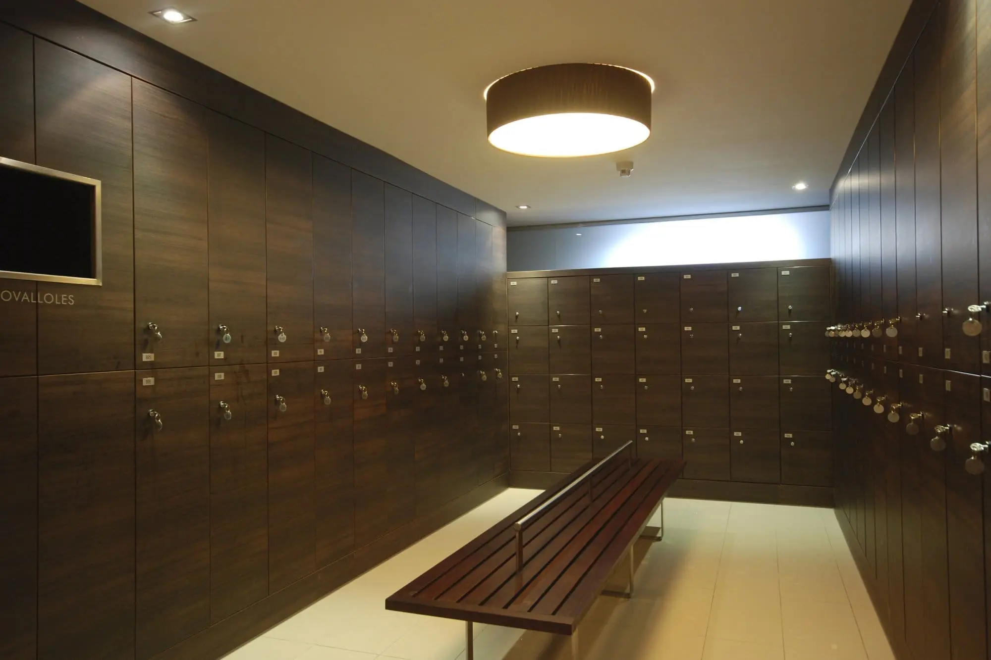 Vestuarios y taquillas a medida fabricadas en HPL con Banco de madera personalizado.